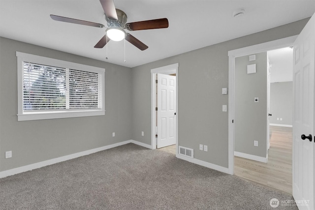unfurnished bedroom with a ceiling fan, baseboards, light colored carpet, and visible vents