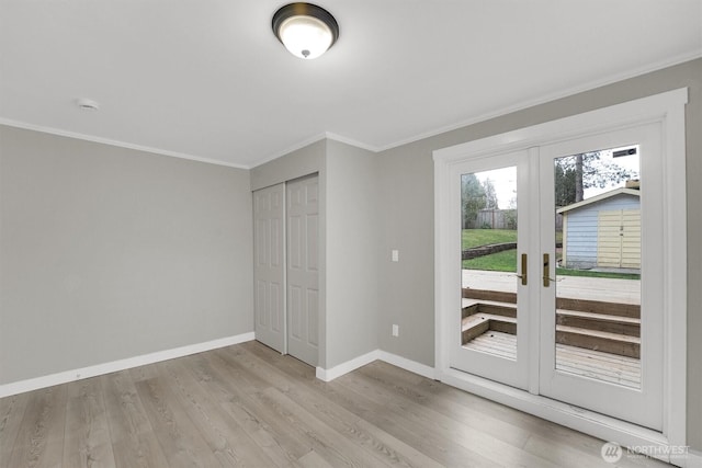 unfurnished bedroom featuring ornamental molding, baseboards, access to exterior, and light wood finished floors