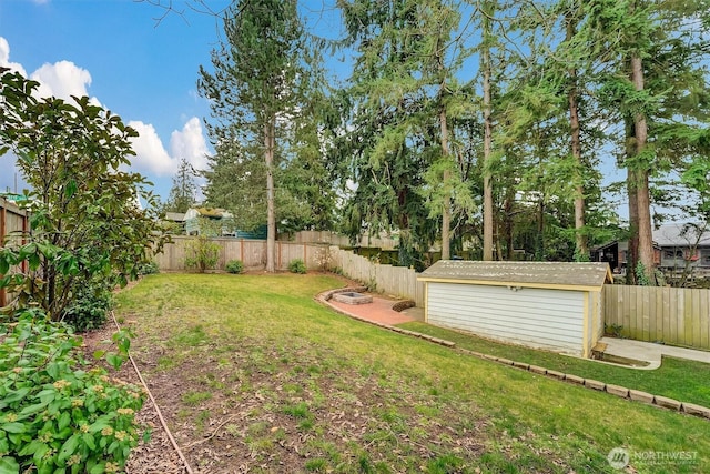 view of yard featuring an outbuilding, a storage unit, and a fenced backyard