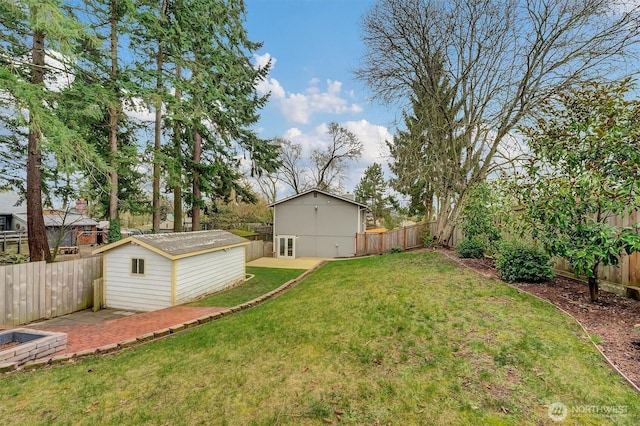 view of yard with a fenced backyard, an outdoor structure, and a storage shed