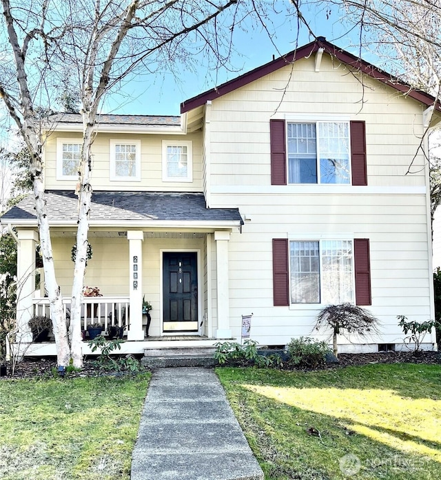 view of front of home featuring a shingled roof, a front yard, and covered porch