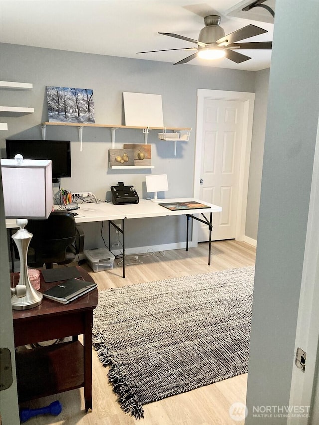 home office featuring a ceiling fan, baseboards, and wood finished floors