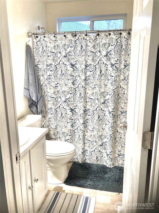 full bathroom with curtained shower, vanity, and toilet