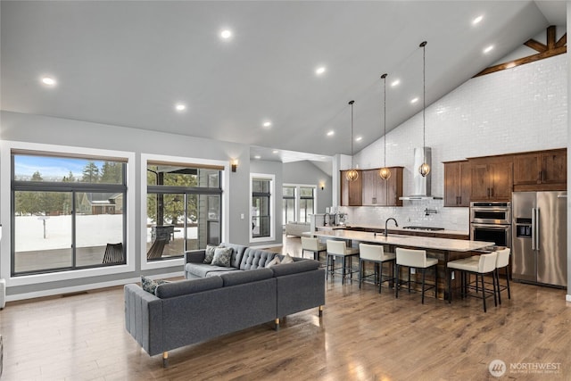 living area with high vaulted ceiling, dark wood finished floors, visible vents, and recessed lighting