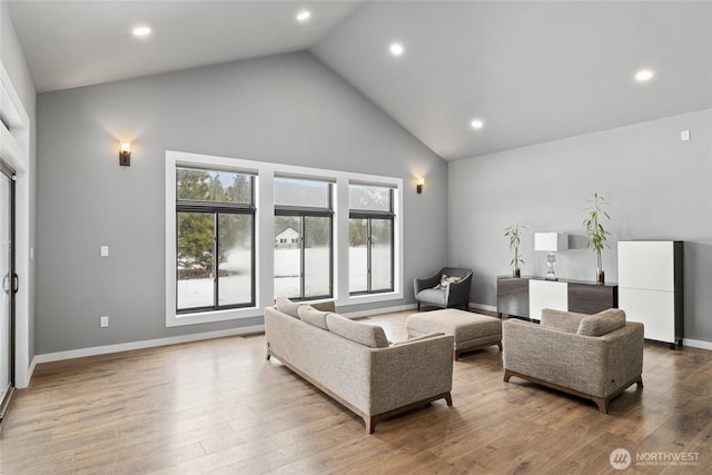 living room with high vaulted ceiling, recessed lighting, wood finished floors, and baseboards