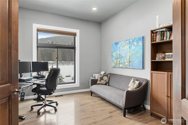 home office featuring visible vents, baseboards, and wood finished floors