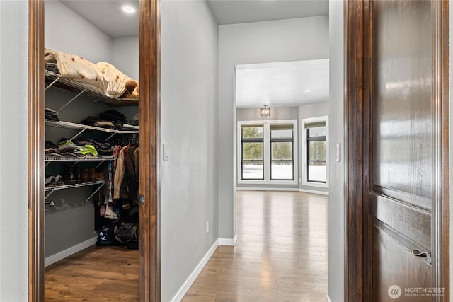 corridor featuring wood finished floors and baseboards