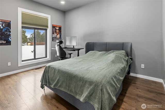 bedroom featuring baseboards, visible vents, and wood finished floors