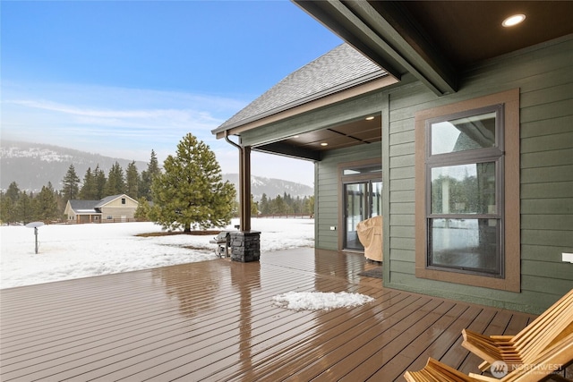 snow covered deck featuring a mountain view