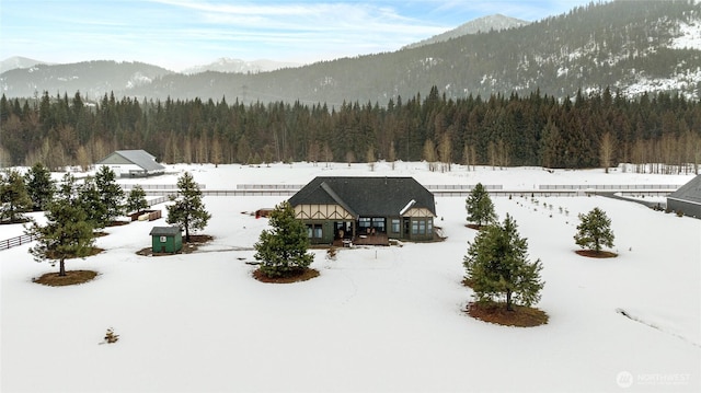 snowy aerial view with a forest view and a mountain view