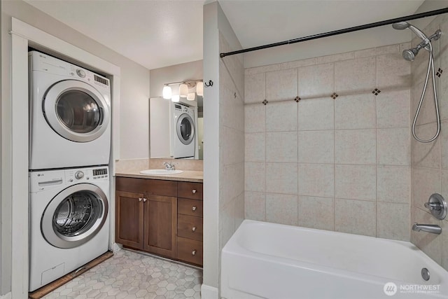 washroom featuring a sink, laundry area, light tile patterned floors, and stacked washer / drying machine