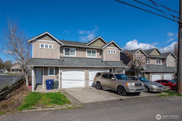 townhome / multi-family property with driveway, a shingled roof, a residential view, an attached garage, and board and batten siding