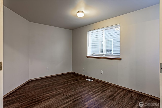 unfurnished room featuring dark wood-type flooring and baseboards