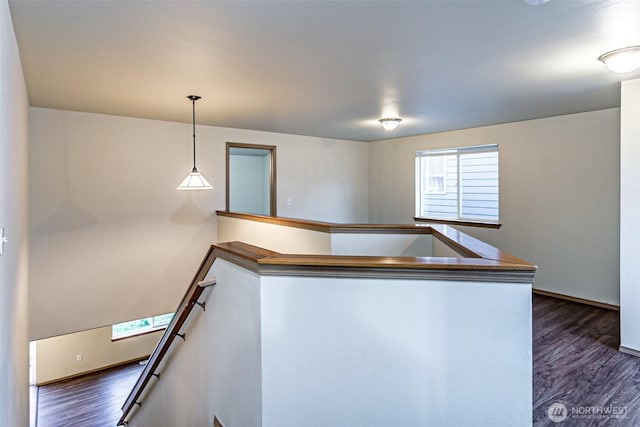 kitchen featuring a peninsula, dark wood-style floors, baseboards, and pendant lighting