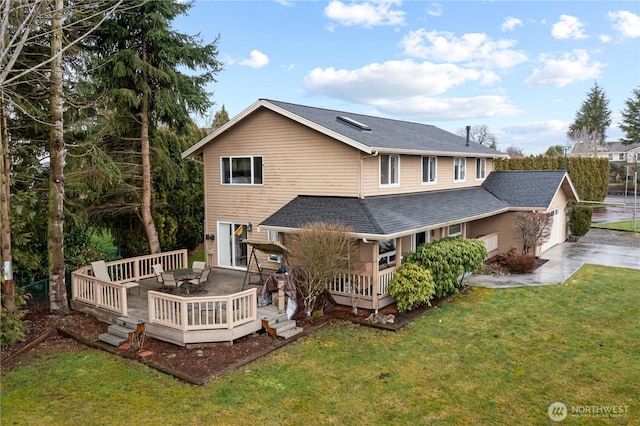 back of house with outdoor dining area, a yard, concrete driveway, an attached garage, and a deck