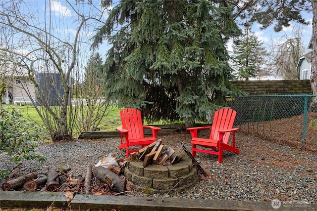 view of yard with an outdoor fire pit and fence