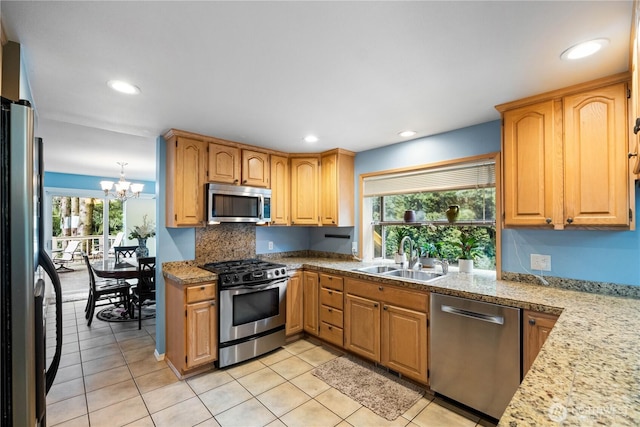 kitchen featuring a sink, stainless steel appliances, light countertops, and a healthy amount of sunlight