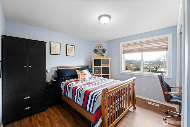 bedroom with dark wood finished floors, visible vents, and baseboards