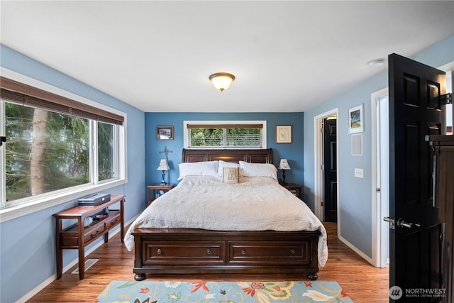 bedroom featuring light wood-style flooring, visible vents, and baseboards