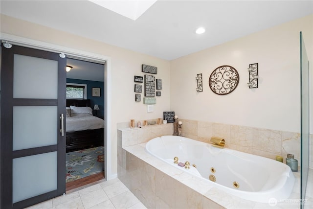 ensuite bathroom featuring a skylight, a whirlpool tub, ensuite bath, and tile patterned floors