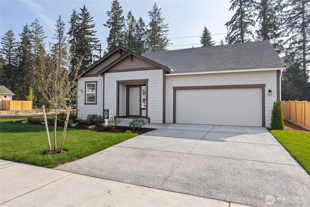 view of front of property with a shingled roof, concrete driveway, fence, a garage, and a front lawn