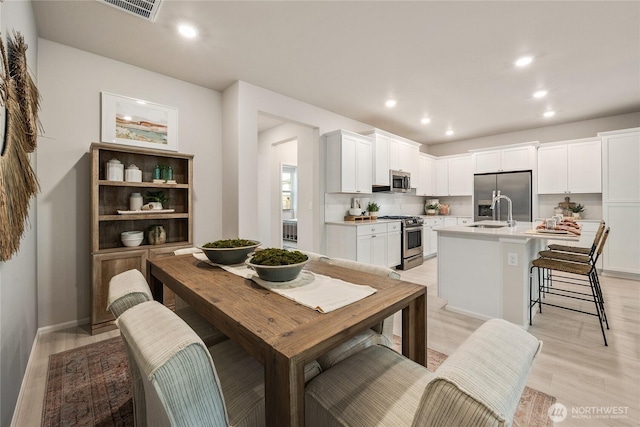 dining room with recessed lighting, visible vents, and light wood finished floors