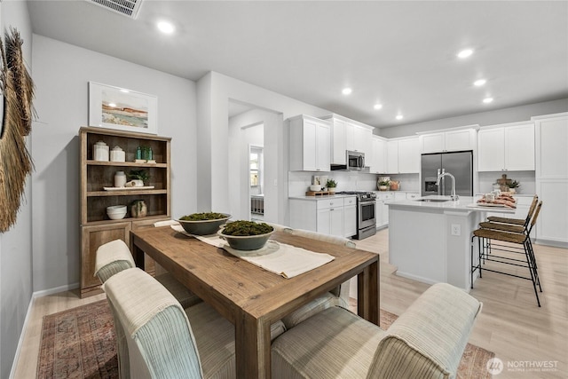 dining area featuring light wood-style flooring, visible vents, and recessed lighting