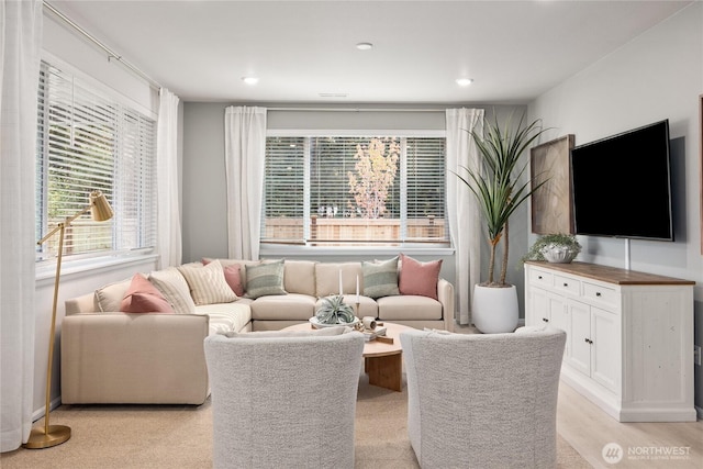 living area featuring light wood-style flooring and recessed lighting