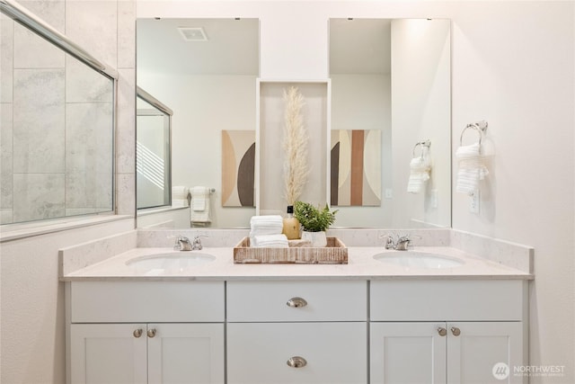 bathroom with visible vents, a sink, and double vanity