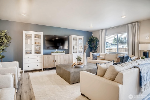 living area with light wood-type flooring and recessed lighting