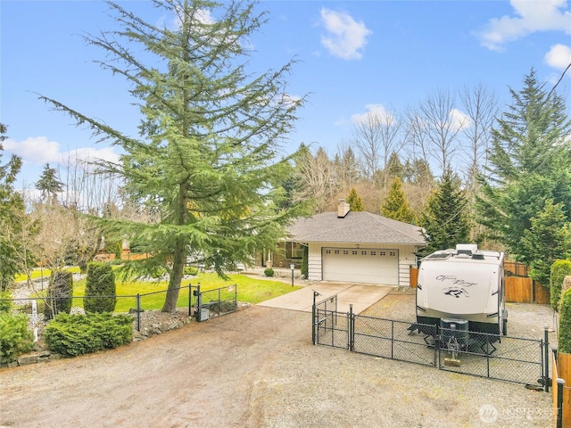 view of front of house featuring dirt driveway, an attached garage, fence, and a gate