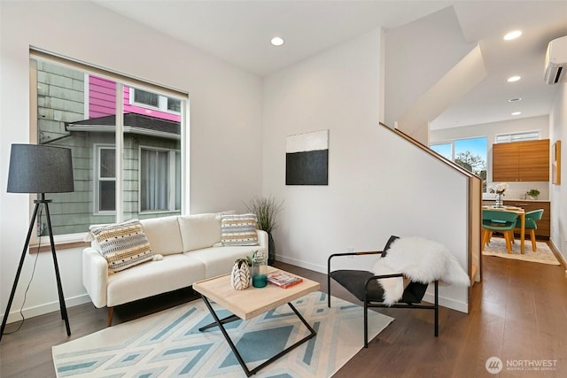 living room with stairs, recessed lighting, wood finished floors, and baseboards