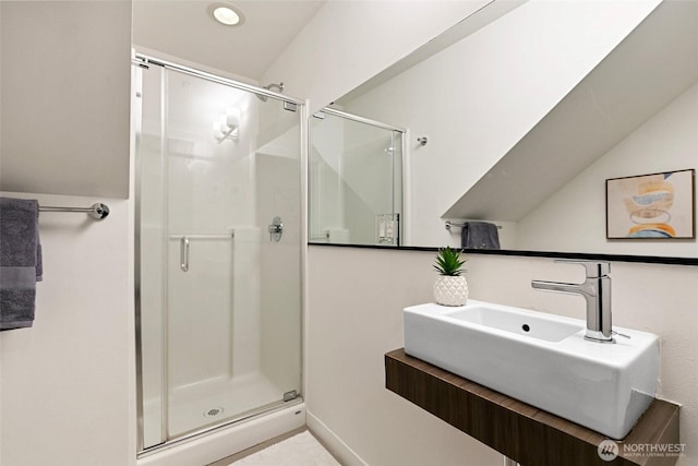 full bathroom with lofted ceiling, a stall shower, and a sink