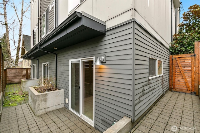 view of side of home featuring fence and a patio