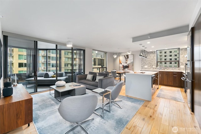 living room with light wood-style floors and floor to ceiling windows