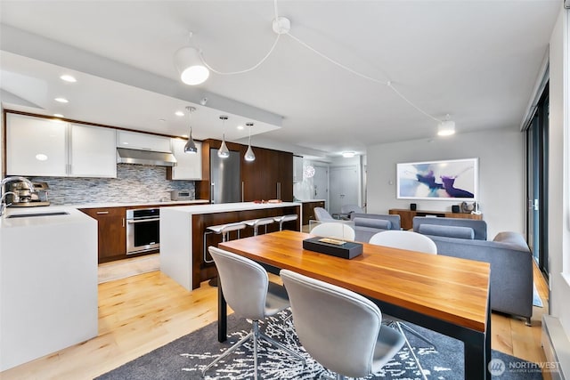 dining area with recessed lighting and light wood-style floors