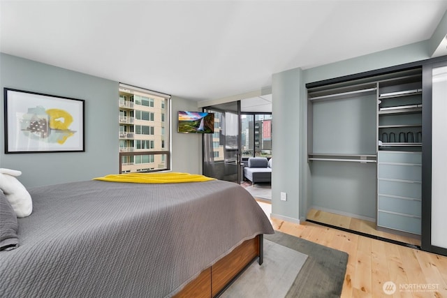 bedroom with baseboards and wood finished floors