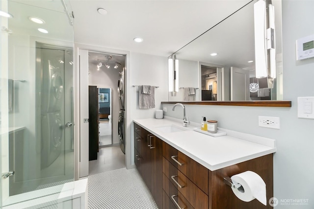 full bath with tile patterned floors, recessed lighting, stacked washer / drying machine, and vanity