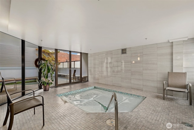 view of swimming pool featuring an indoor hot tub