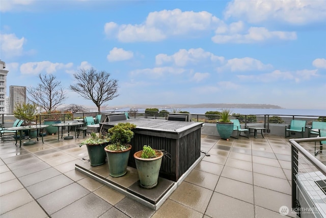 view of patio with a water view and outdoor dining area