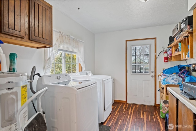 washroom featuring cabinet space, dark wood-style flooring, washing machine and clothes dryer, a textured ceiling, and water heater