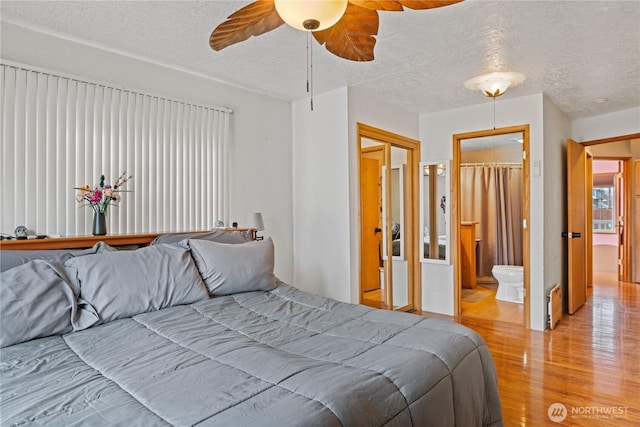 bedroom with a textured ceiling, ceiling fan, wood finished floors, and ensuite bathroom