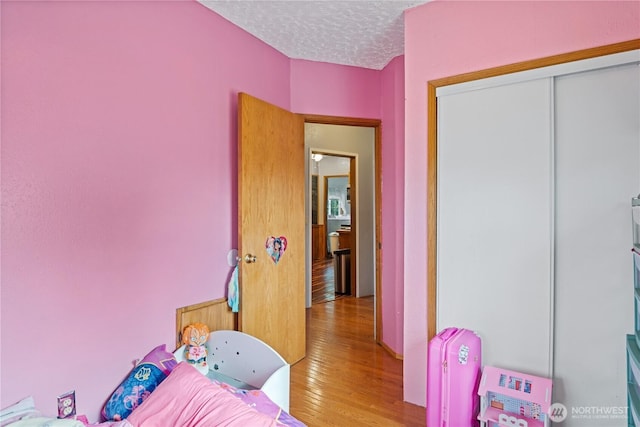 rec room featuring a textured ceiling and hardwood / wood-style floors