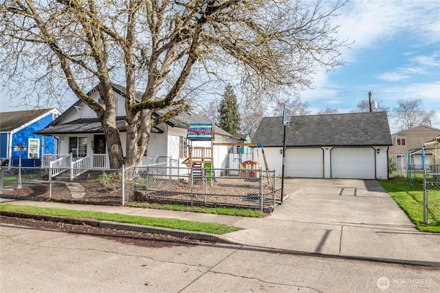 view of front of house with an outbuilding, a playground, an attached garage, fence, and driveway