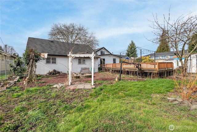 rear view of house featuring a deck and a lawn