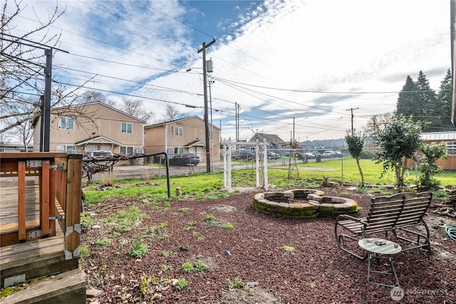 view of yard with a residential view, fence, and a fire pit