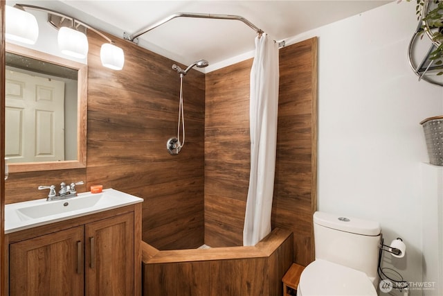 full bathroom featuring toilet, tiled shower, and vanity