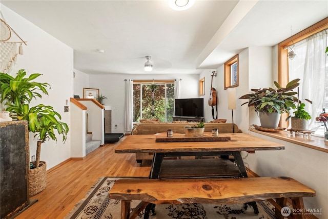 dining area with stairs, baseboards, and light wood-style floors