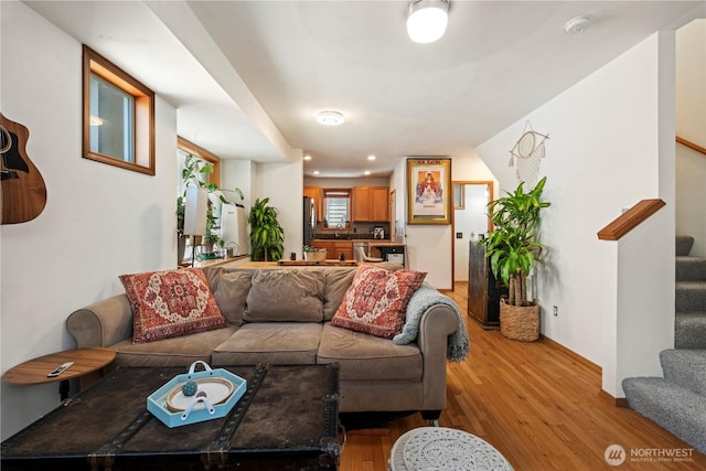 living area featuring light wood-style floors, recessed lighting, and stairs