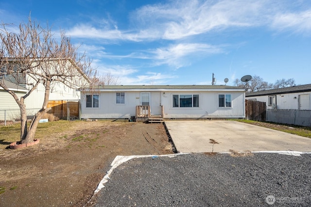 ranch-style house featuring fence